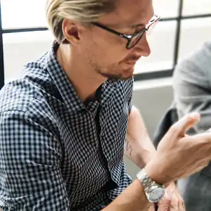 A man is looking at his phone to check the status of his refund.